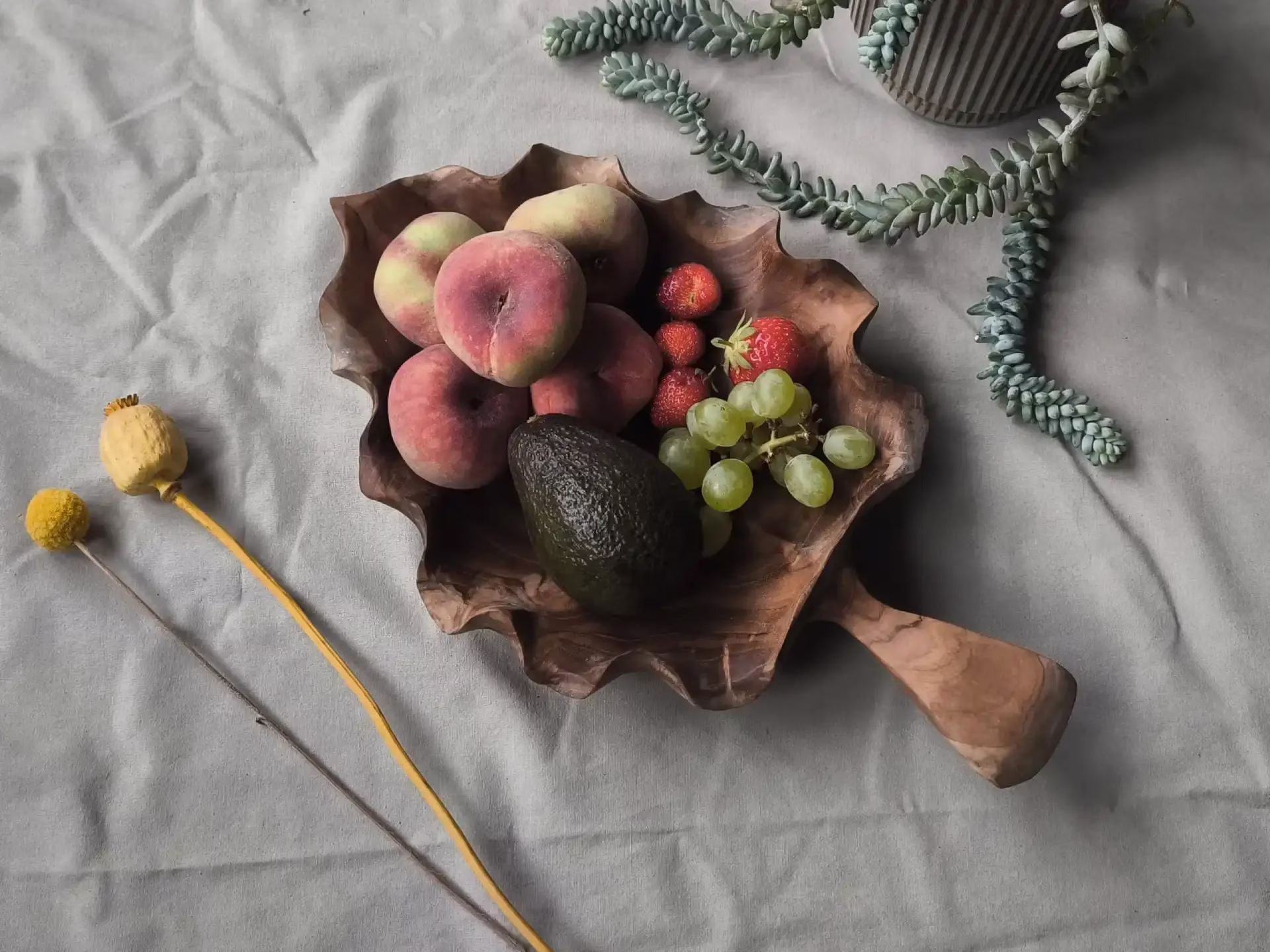 Everleaf boomblad gevuld met fruit op een kleed met wat andere decoraties